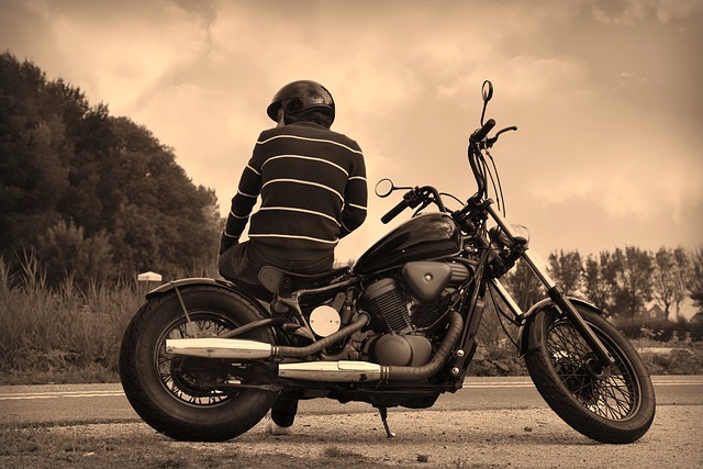 muž s prilbou pózujúci na motorke